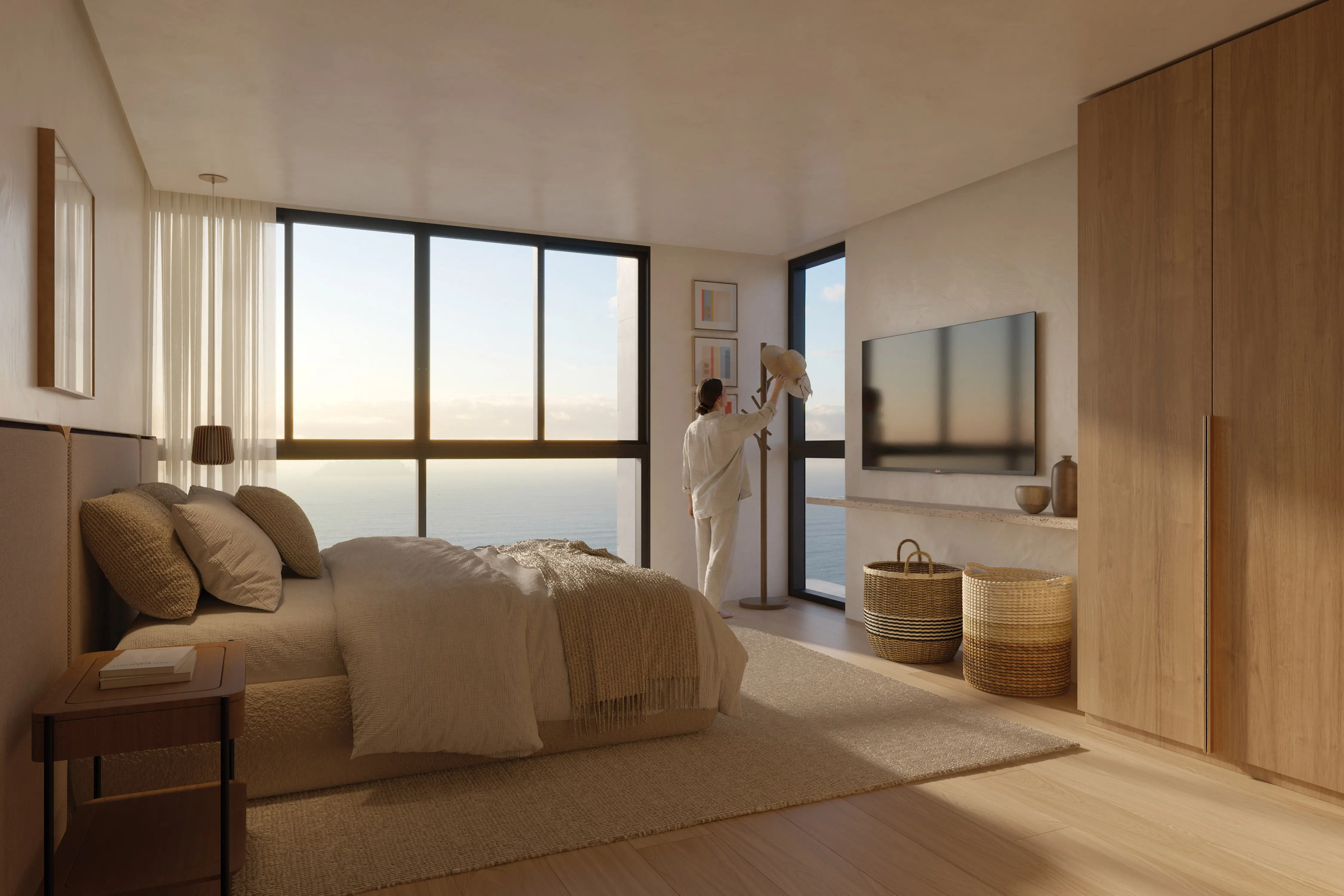 Suíte do duplex do Nuar Residence em Balneário Piçarras, com cama de casal, roupão em madeira, TV, luminária de chão, cestos decorativos e ampla janela com vista privilegiada para o mar ao entardecer
